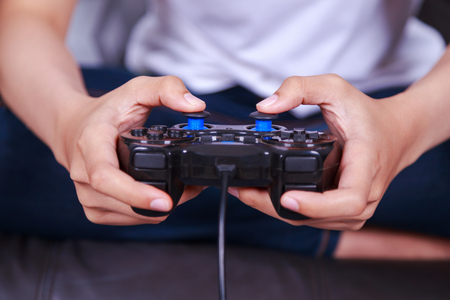 Close up of hand playing the video game with a joystick