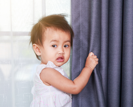 portrait of baby near the window at homeの写真素材