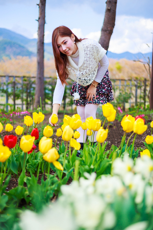 beautiful woman with tulips flowers in the gardenの写真素材