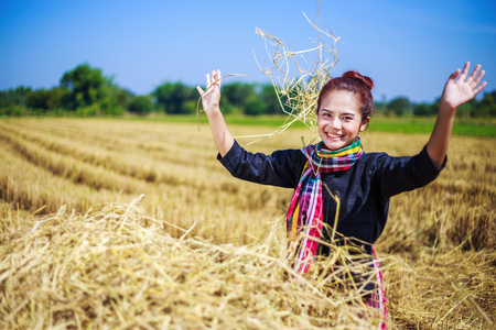 farmer woman relaxing with the straw in field, Thailandの写真素材