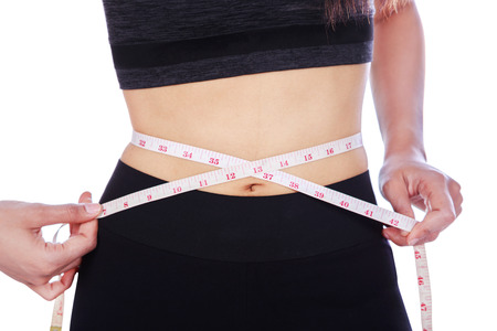 close up woman measuring waist with tape isolated on white background