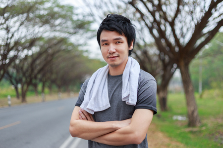 sporty man with arms crossed in the parkの写真素材