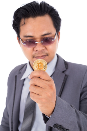 man holding golden bitcoin in hand isolated on a white backgroundの写真素材