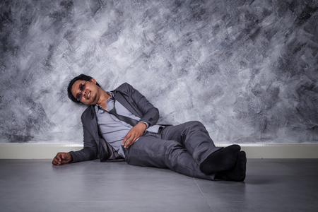 young depressed businessman sitting on the floorの写真素材