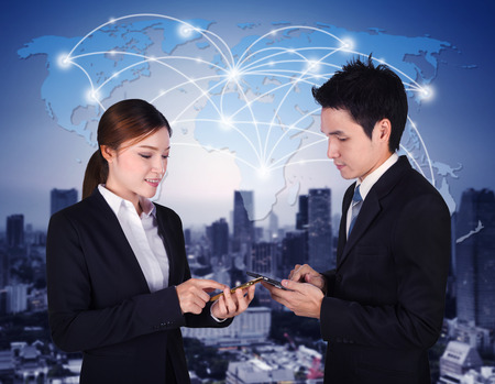 man and woman using smartphone with world social media network connectionの写真素材