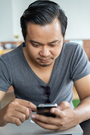 young man using smartphone in a cafeの写真素材