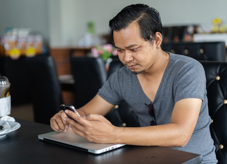 young man using smartphone in a cafeの写真素材