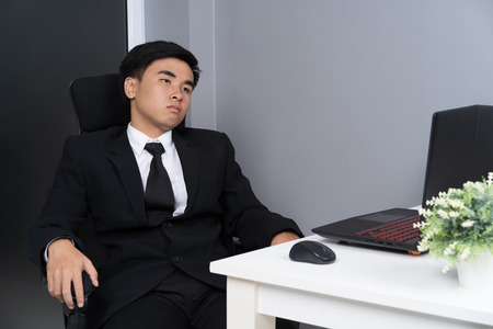 young business man sitting on chair and thinkingの写真素材