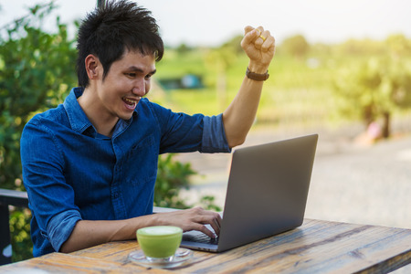 cheerful man using laptop computer on table