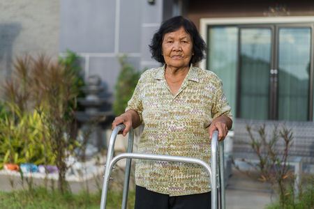senior woman walking with walker at homeの写真素材