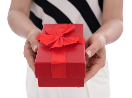 woman holding a gift box in a gesture of giving isolated on white background