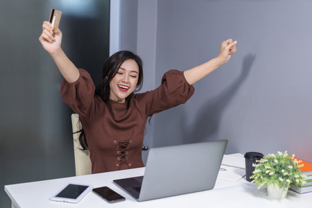 successful woman using laptop computer for online shopping with a credit cardの写真素材