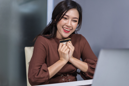 happy woman using laptop computer for online shopping with a credit cardの写真素材