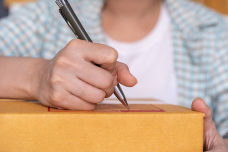hands of woman writing on parcel box, online business, prepare before deliveryの写真素材