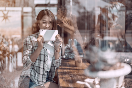 happy woman using digital tablet in a cafeの写真素材