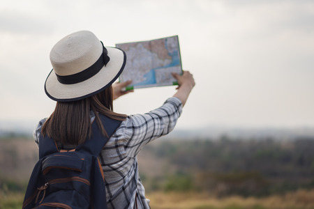 woman traveler searching direction on location map while travelingの写真素材