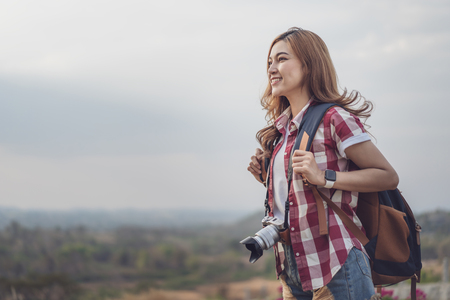 female tourist with backpack and camera in the countrysideの写真素材