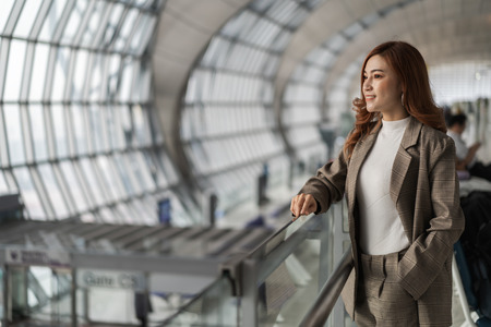 beautiful woman waiting for flight in airportの写真素材
