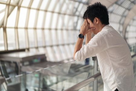 Stressed man waiting flight in airportの写真素材