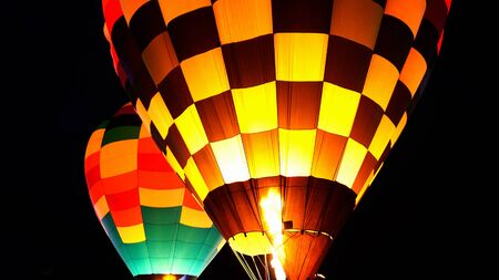 close up of hot air balloon with burner flame glowing at a nightの写真素材