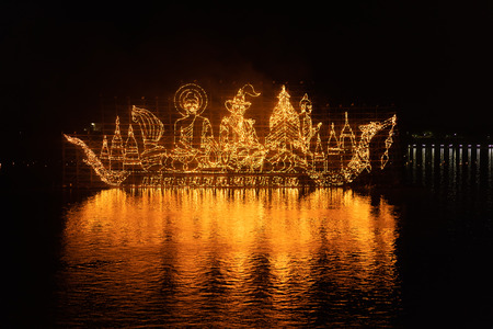NAKHON PHANOM, THAILAND - OCTOBER 13, 2019: Traditional fire boat floating in Mekong river at night in Nakhon Phanom, Thailandのeditorial素材
