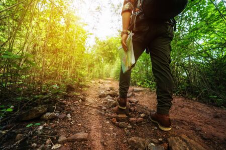 close up hiking man with trekking boots walking in the natural forest