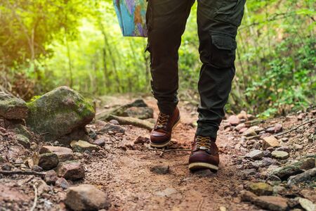 close up hiking man with trekking boots walking in the natural forest
