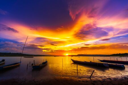 wooden boat at banks of the river with sunset in Khonburi, Nahon Ratchasima province, Thailand.の写真素材