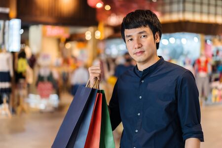 young asian man shopping with bag at mallの写真素材