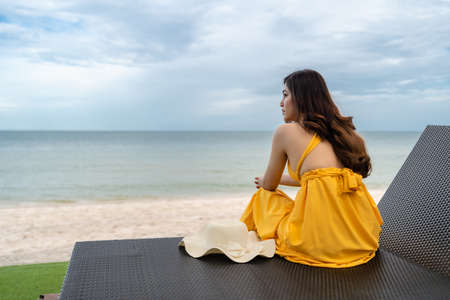 young woman relaxing on a chair in Hua Hin beach, Thailandの写真素材