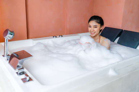 woman in bikini relaxing inside a bathtub