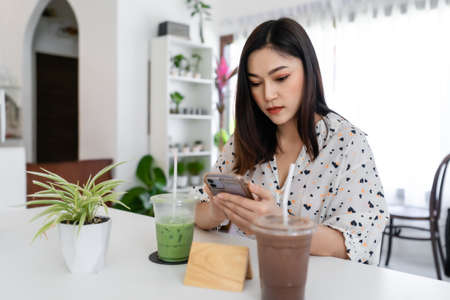 young woman using smartphone in cafeの写真素材