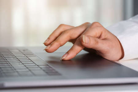 close-up female hand touching touchpad on a laptop computerの写真素材