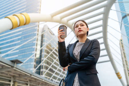woman holding a cup of coffee and thinking about problem of her business in the cityの写真素材