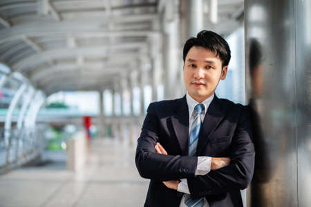 business man in suit with arcs crossed and thinking in the cityの写真素材