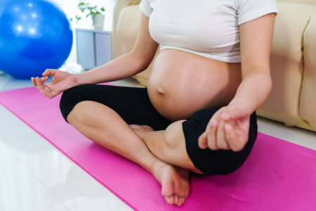 pregnant woman doing yoga exercise in the living room at homeの写真素材