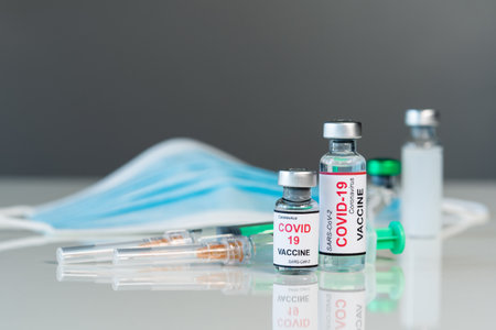 coronavirus covid-19 vaccine bottles and syringe injection medicine and medical maskの写真素材