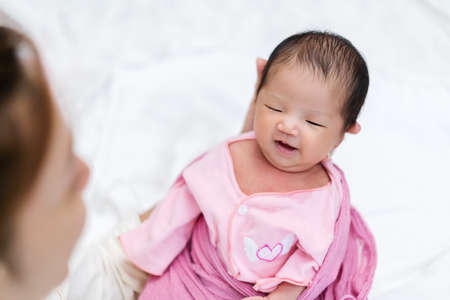 mother holding happy newborn baby in her armの写真素材