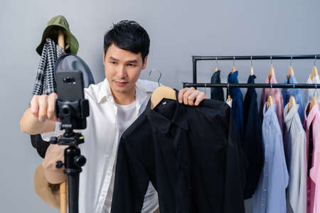 young man selling clothes and accessories online by smartphone live streaming, business online...