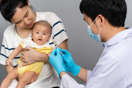 doctor vaccines or injection to baby with mother holding