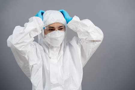 stressed doctor in protective PPE suit during coronavirus(covid-19) pandemicの写真素材