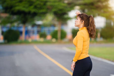 tired woman taking a rest after running or exercise in the parkの写真素材