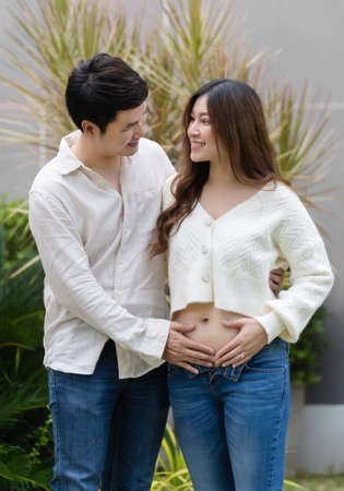 married couple is expecting a baby. man embraces his pregnant wife.の写真素材