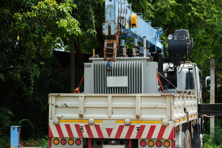 power transformer strapped on a truck and crane arm
