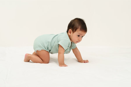 infant crawling on floor inside a baby playpenの写真素材