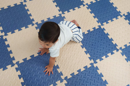 top view of infant baby crawling on play mat or jigsaw floorの写真素材