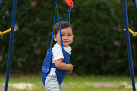 happy infant baby jumping in the jumper swing