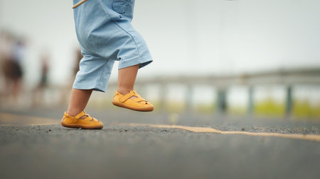 close up leg of infant baby learning to walking first step on a pathwayの写真素材