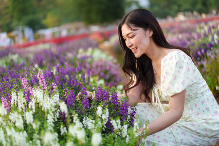 beautiful woman in a dress enjoying Angelonia flower blooming in fieldの写真素材