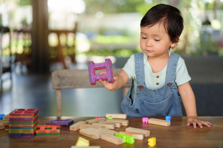 toddler girl playing toy on a tableの写真素材